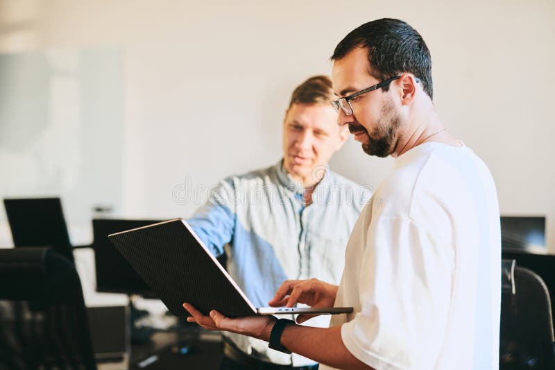 Portrait of two professional male programmers working on computer in diverse offices. Modern IT technologies royalty free stock photo