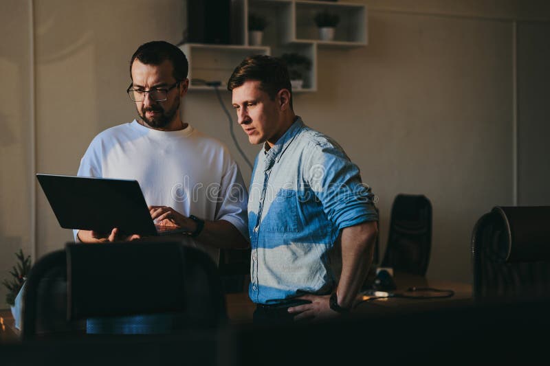 Portrait of two professional male programmers working on computer in diverse offices. Modern IT technologies stock images