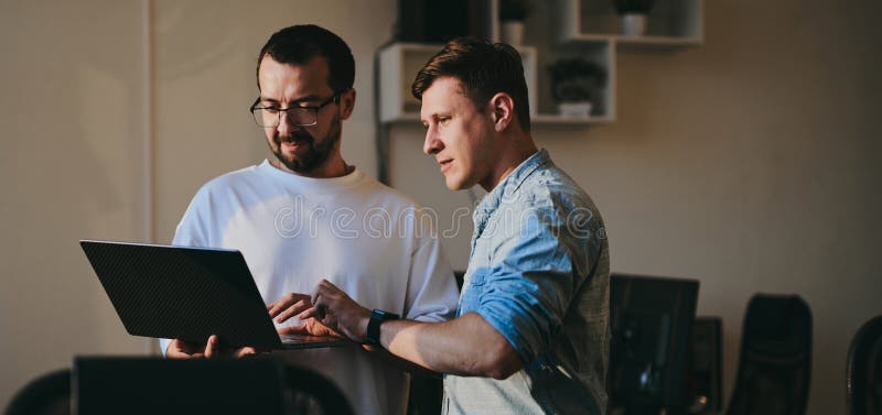 Portrait of two professional male programmers working on computer in diverse offices. Modern IT technologies stock photos
