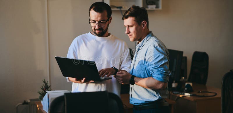 Portrait of two professional male programmers working on computer in diverse offices. Modern IT technologies stock photo