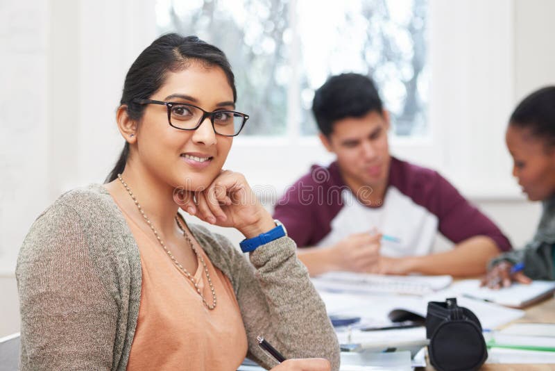 Portrait une fille indienne et une étudiante avec le sourire en classe et lunettes pour la vision au lycée. heureux et fier photographie stock