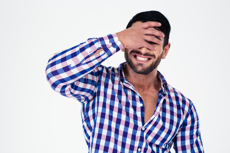 Portrait of upset man covering his eyes isolated on a white background