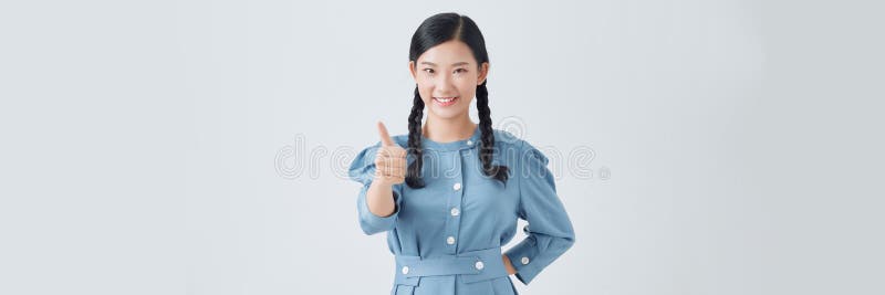 Portrait von attraktiven positiven lächelnden Frau mit Braiden hält Daumen erhöht zeigt ihre Zustimmung lizenzfreies stockfoto