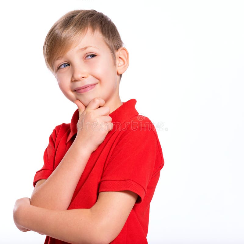 Portrait of white smiling kid in a red t-shirt looking away.  Photo of a thinking  boy looking away.  Caucasian boy with a sly