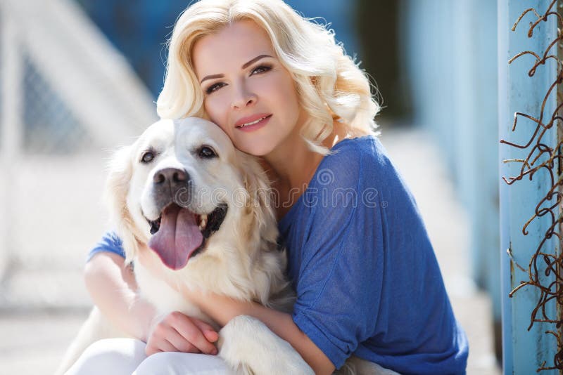 Portrait of a woman with beautiful dog playing outdoors.