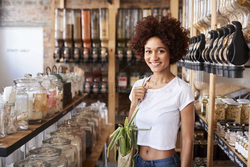 Portrait Of Woman Buying Fresh Fruit And Vegetables In Sustainable Plastic Free Grocery Store stock images Portrait Of Woman Buying Fresh Fruit And Vegetables In Sustainable Plastic Free Grocery Store stock images