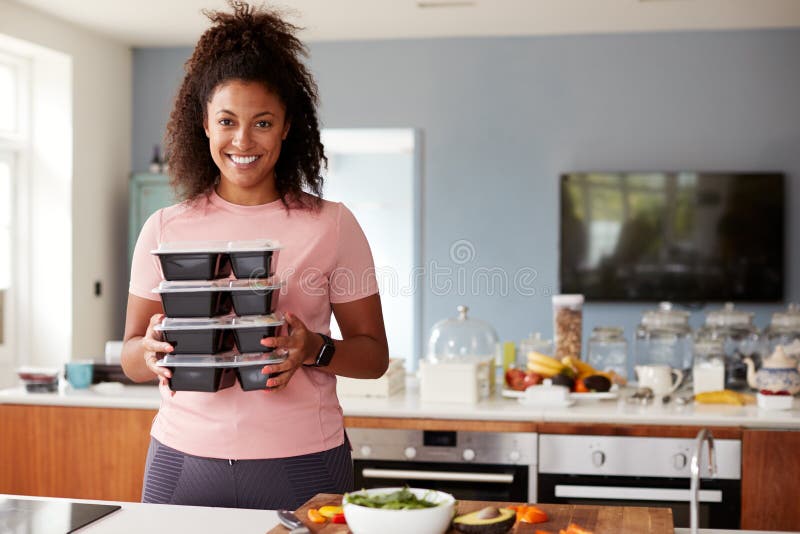 Portrait Of Woman Preparing Batch Of Healthy Meals At Home In Kitchen