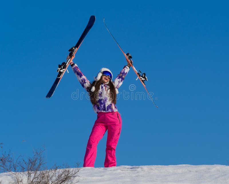 Portrait of a woman with a ski on a mountain peak over blue sky background. Active lifestyle concept stock photo Portrait of a woman with a ski on a mountain peak over blue sky background. Active lifestyle concept stock photo