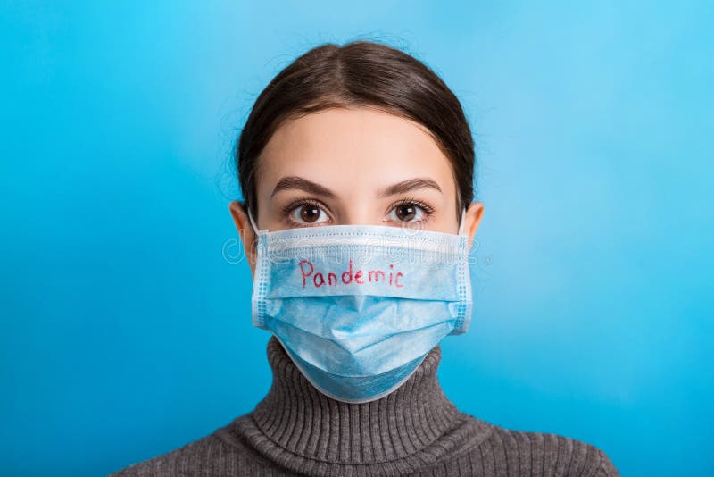 Portrait of a woman wearing medical mask with pandemic word at blue background. and healthcare concept