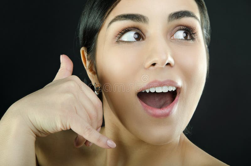 Portrait of a woman who making call me gesture sign with hand