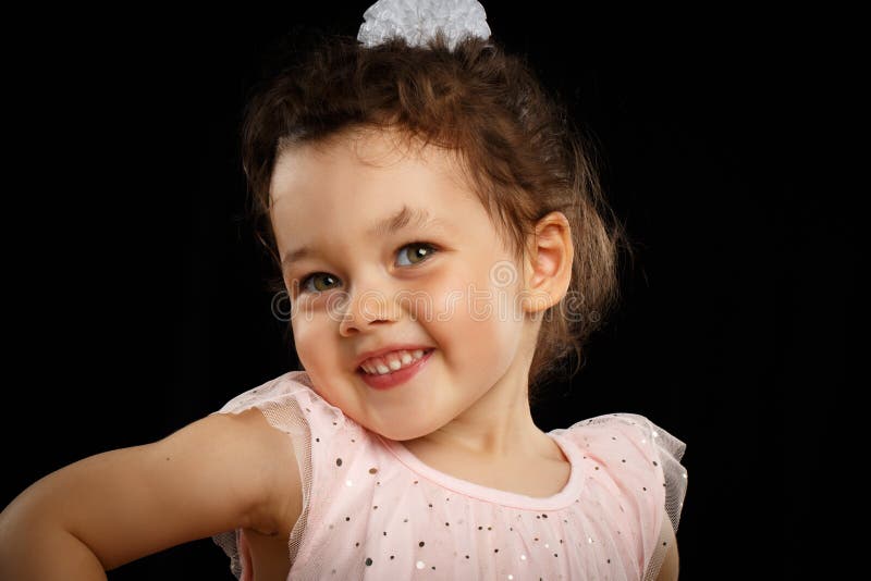 Portrait of 3 year old little girl on black background