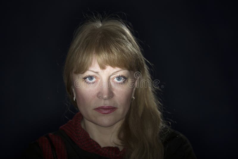 Portrait Of A 50 Years Old Blonde Against A Dark Background Stock