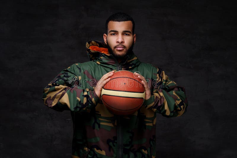 Portrait of a young African-American street basketball player in a camouflage jacket.