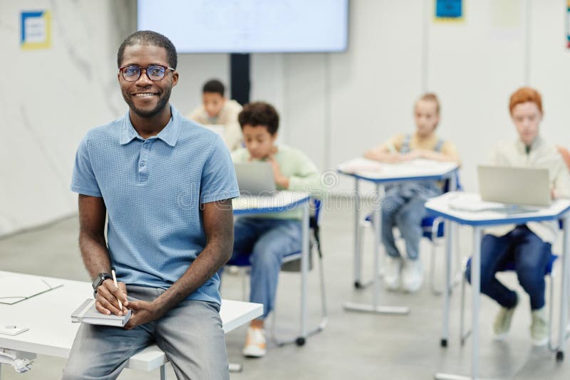 Smiling Teacher in School Classroom stock images