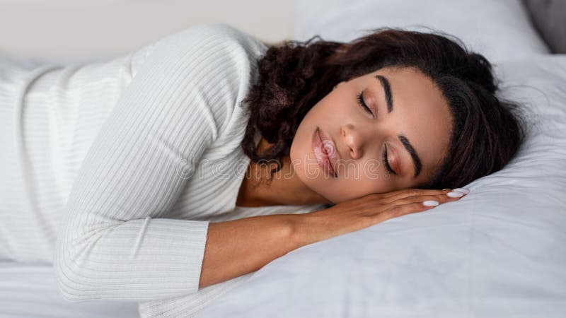 Portrait of young African American woman sleeping in bed