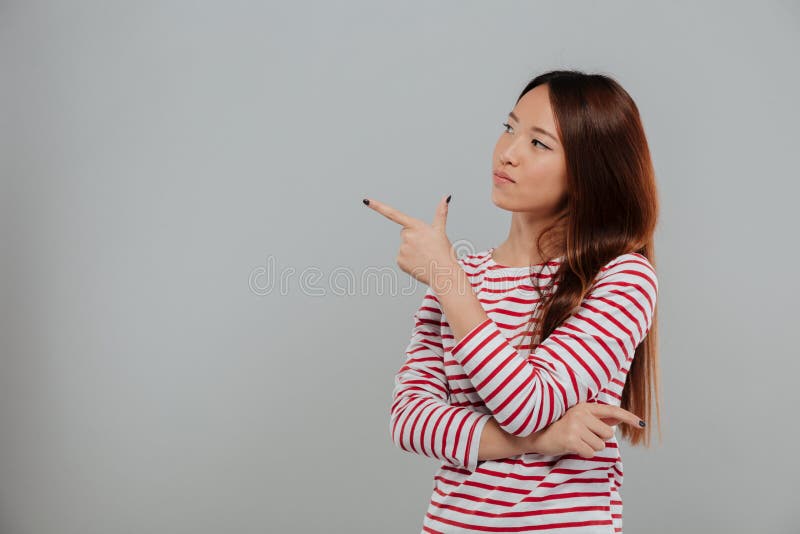 Portrait Of A Young Asian Woman Pointing Finger Away Stock Image