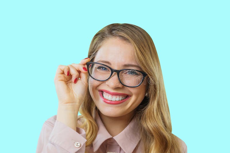 Portrait of a young attractive blonde with glasses who is holding glasses with one hand is smiling with wide white teeth stock photos Portrait of a young attractive blonde with glasses who is holding glasses with one hand is smiling with wide white teeth stock photos