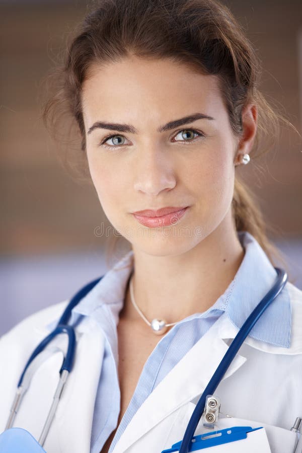 Portrait of young attractive female doctor in hospital, smiling royalty fre...