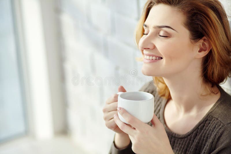Portrait of young attractive smiling woman with a cup of morning coffee or tea. stock image Portrait of young attractive smiling woman with a cup of morning coffee or tea. stock image