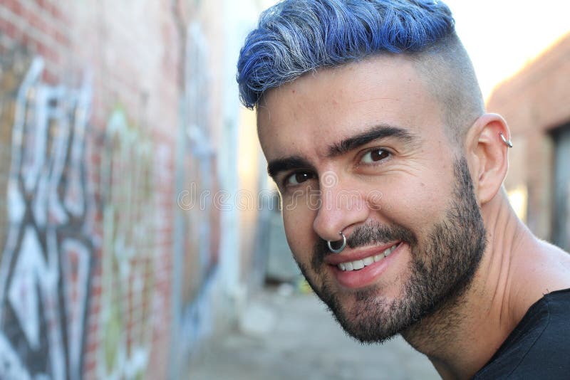 Portrait of young beautiful blue head stylish boy with fancy look smiling.