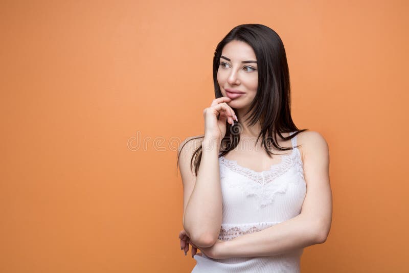 Portrait of a young beautiful brunette pensive woman holding her hand new her chin and looking aside stock image Portrait of a young beautiful brunette pensive woman holding her hand new her chin and looking aside stock image