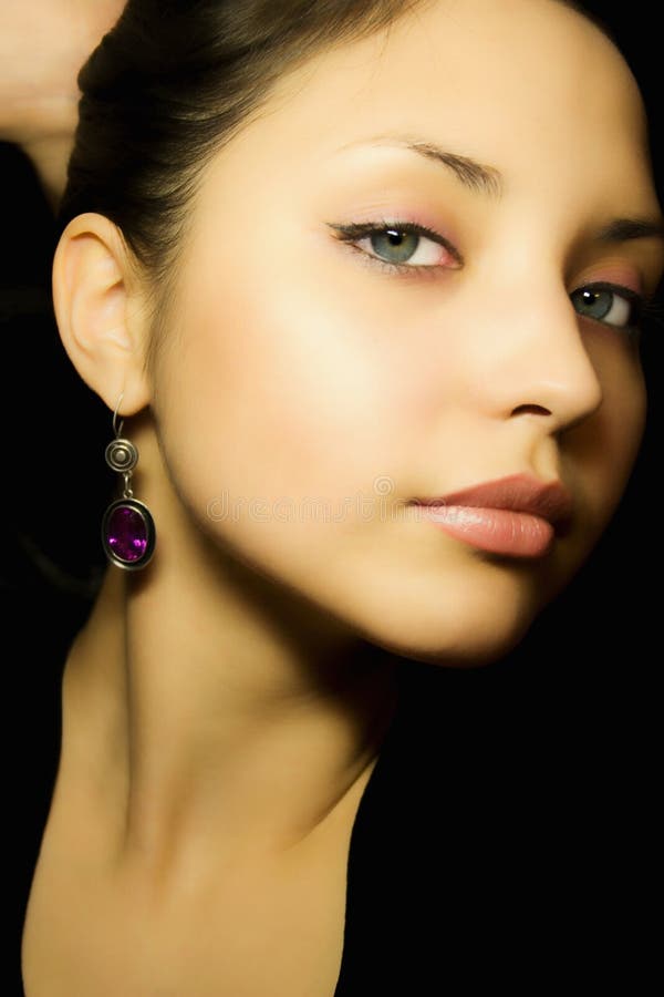 Portrait of a young beautiful girl with earrings