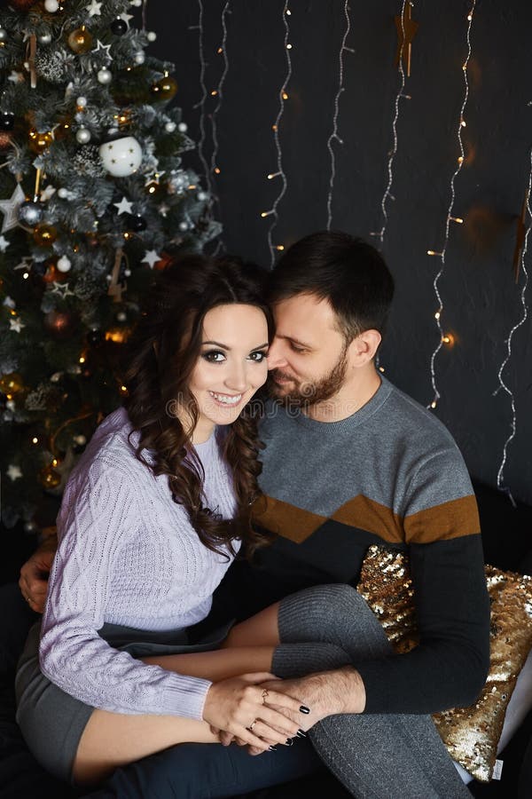 Portrait of young beautiful lovers in the Christmas interior. Handsome man and young beauty in stylish outfit spending royalty free stock photo Portrait of young beautiful lovers in the Christmas interior. Handsome man and young beauty in stylish outfit spending royalty free stock photo