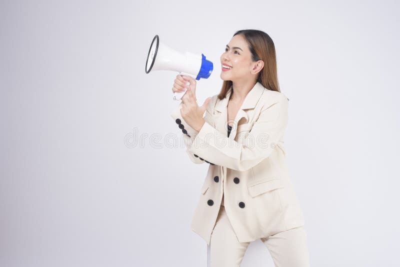 A portrait of young beautiful smiling woman in suit using megaphone to announce over isolated white background studio