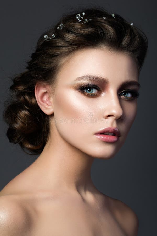 Portrait of young beautiful woman with bridal makeup and coiffure