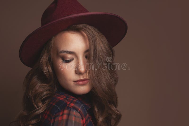 Portrait of young beautiful woman in fedora hat