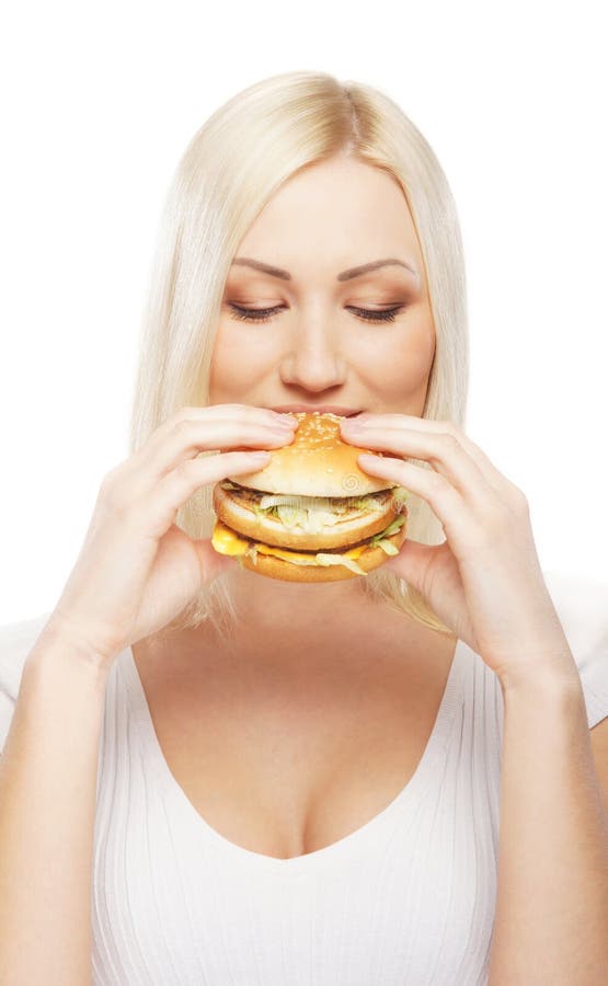 Portrait of a young blond woman eating a burger