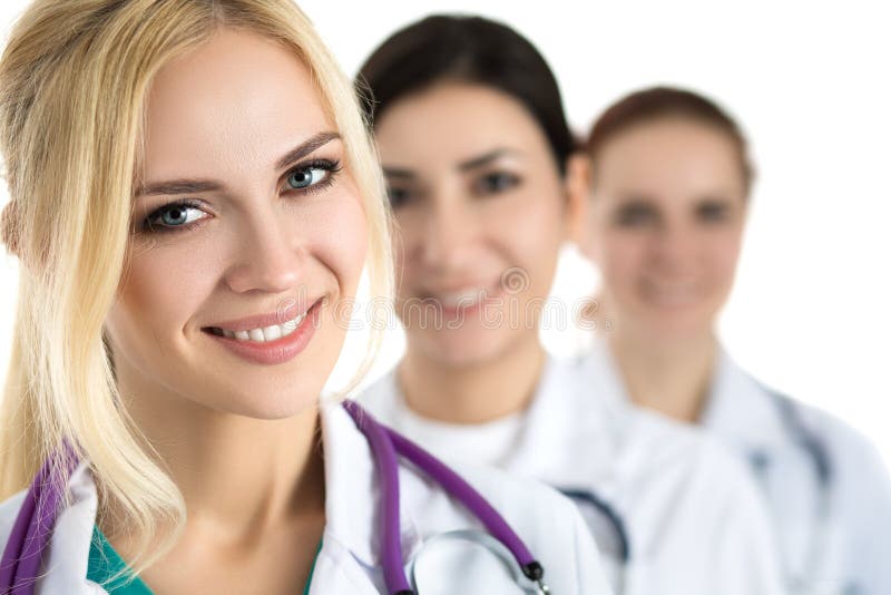 Portrait of young blonde female doctor surrounded by medical team, looking at camera and smiling. Healthcare and medicine concept.