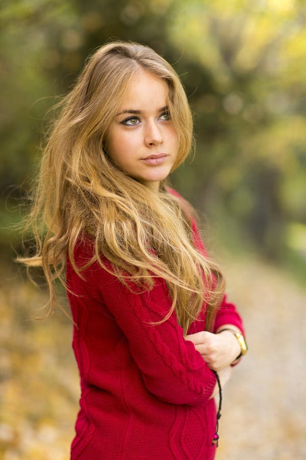 Portrait of a young blonde female on field. Beautiful woman.