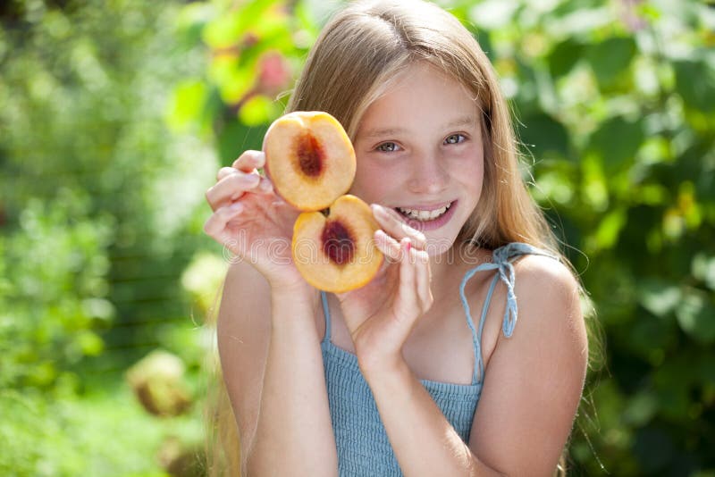 Portrait Of A Young Blonde Little Girl With Peach Stock Photo I