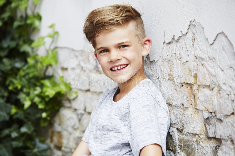Portrait of a Young Boy Against Brick Wall Stock Photo - Image of ...
