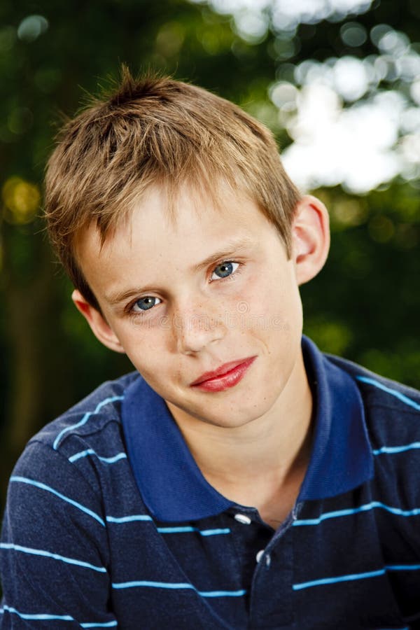 Portrait of a young boy sitting in the garden stock image