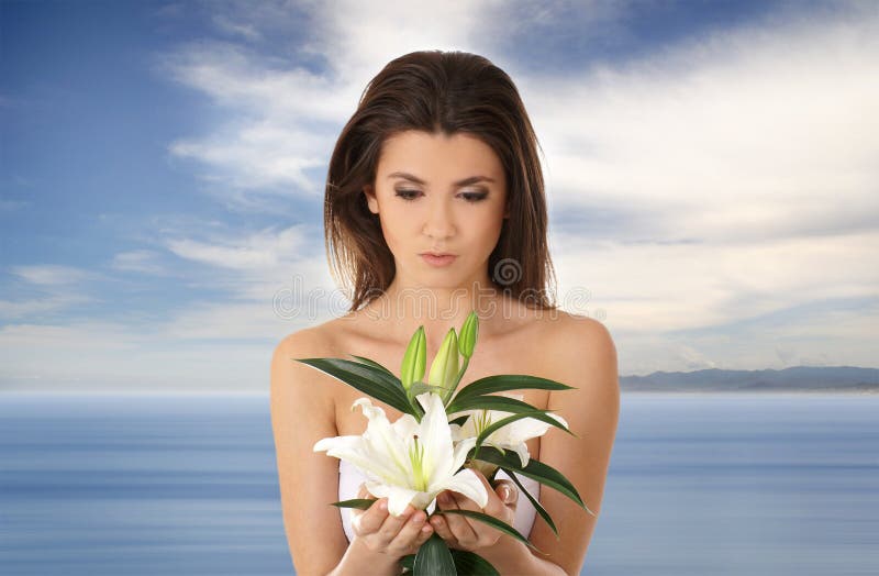 Portrait of a young brunette holding a flower