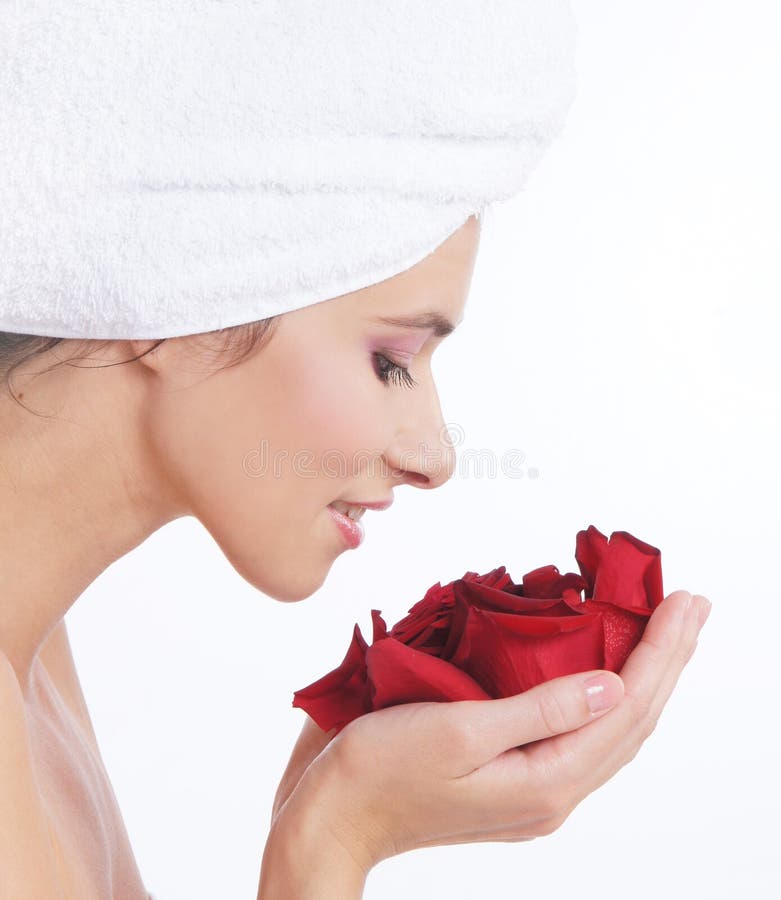 Portrait of a young brunette holding rose petals