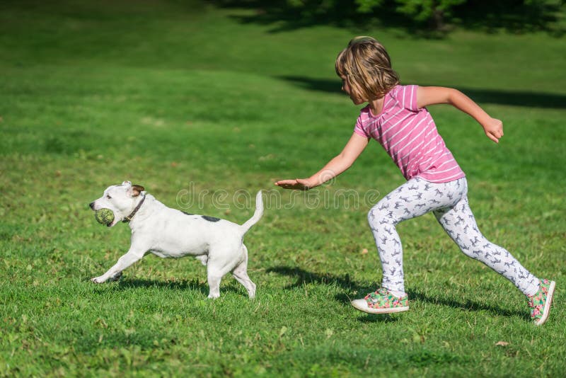Girl chasing a dog in a park
