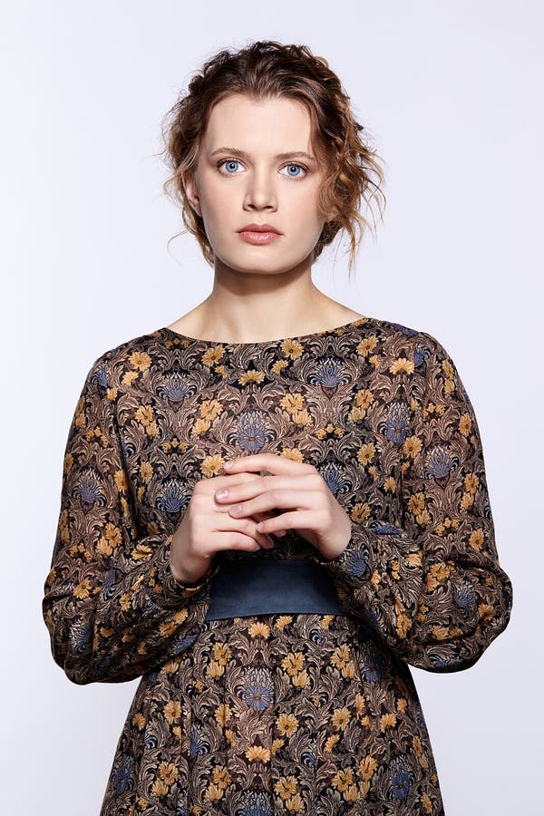 Portrait of a young caucasian woman in vintage retro dress and wavy hair on a gray background royalty free stock image Portrait of a young caucasian woman in vintage retro dress and wavy hair on a gray background royalty free stock image