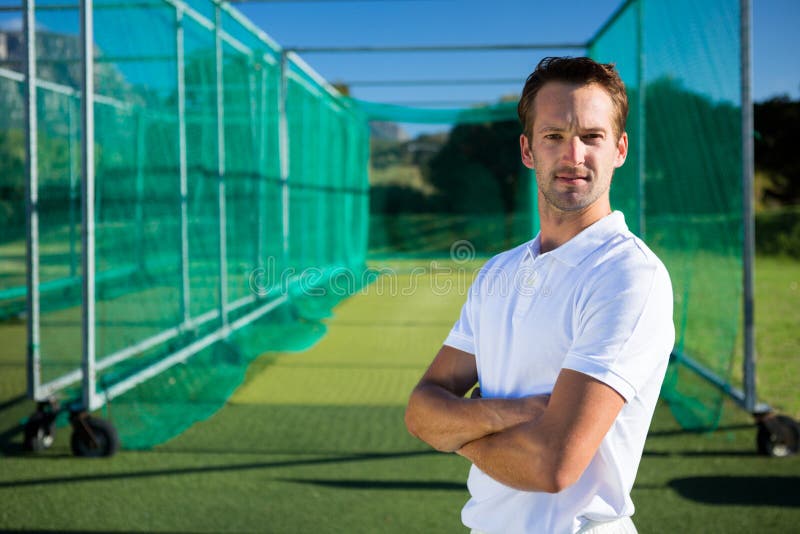 Portrait of young cricketer with arms crossed standing on field royalty free stock photos Portrait of young cricketer with arms crossed standing on field royalty free stock photos