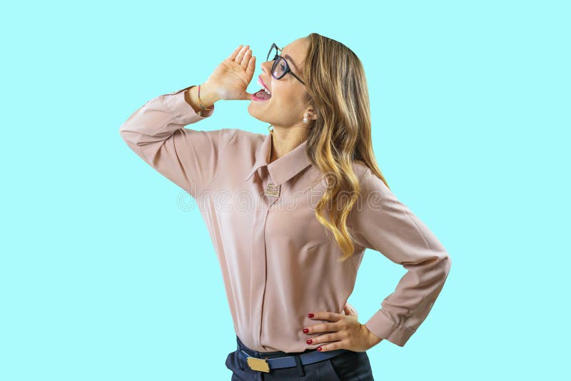 Portrait of a young curly blonde in glasses who shouts holding a hand to her mouth looking to the side on a blue royalty free stock images Portrait of a young curly blonde in glasses who shouts holding a hand to her mouth looking to the side on a blue royalty free stock images