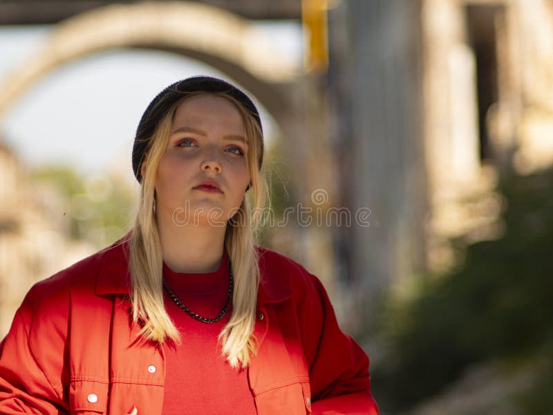 Portrait of a young girl blonde teenager in a knitted black hat on the street stock photo Portrait of a young girl blonde teenager in a knitted black hat on the street stock photo