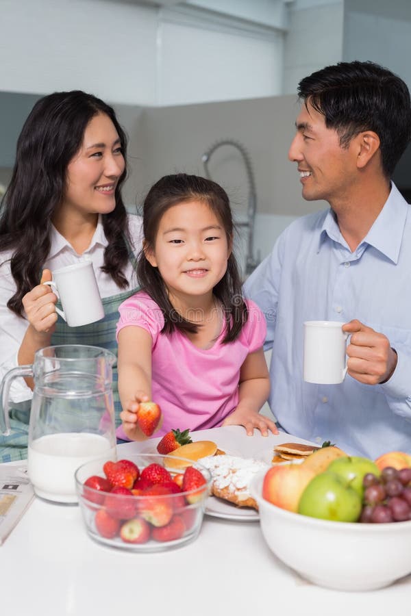 Portrait of a Young Girl Enjoying Breakfast with Parents Stock Photo ...