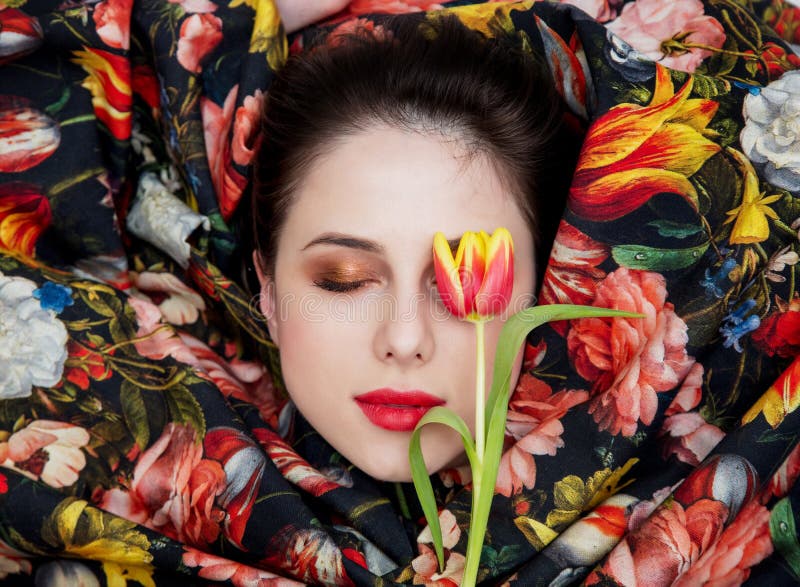 Portrait of a young girl with red lipstick and shrouded flower fabric