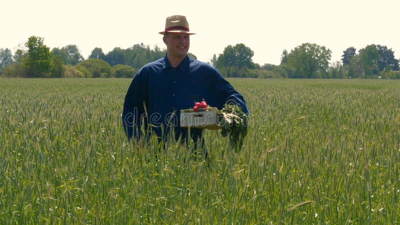 Portrait of a young guy man in a working uniform and a straw hat in the middle of a field around wheat and hay, running around i stock photography Portrait of a young guy man in a working uniform and a straw hat in the middle of a field around wheat and hay, running around i stock photography