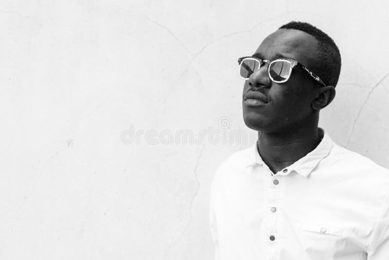 Young handsome African man against concrete wall outdoors royalty free stock photography Young handsome African man against concrete wall outdoors royalty free stock photography