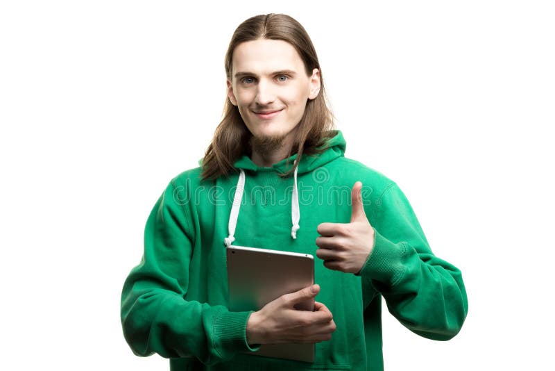 Portrait of a young handsome man in green hoodie looking at the camera, holding a digital tablet in one hand and showing okay gest royalty free stock image Portrait of a young handsome man in green hoodie looking at the camera, holding a digital tablet in one hand and showing okay gest royalty free stock image