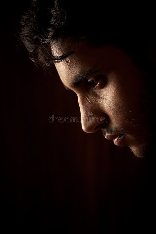 Portrait of young Indian angry man over dark