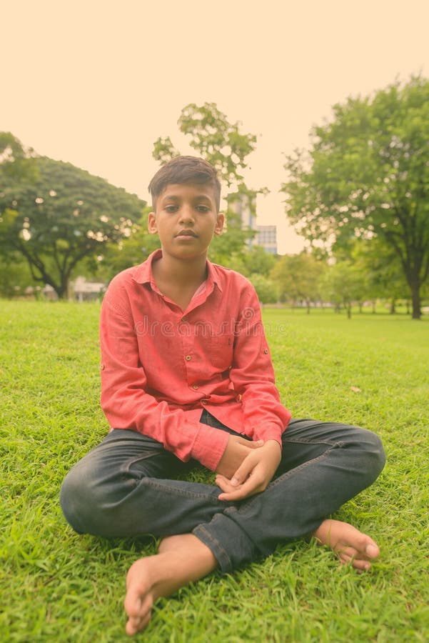 Portrait Of Young Indian Boy Relaxing At The Park Stock I